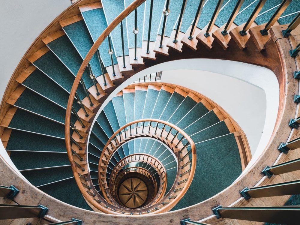 Cage d’escalier d’immeuble vue de haut, rampes et paliers entretenus